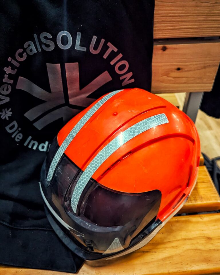 Oranger JSP-Schutzhelm mit Reflexstreifen auf der Arbeitsjacke