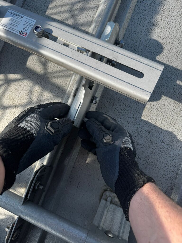 Montage einer Metallschiene auf dem Dach mit Ironshield-Stoßschutzhandschuhen