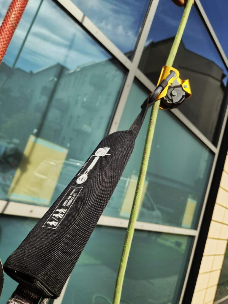 Petzl ASAP mit Falldämpfer am Sicherungsseil vor der Glasfassade
