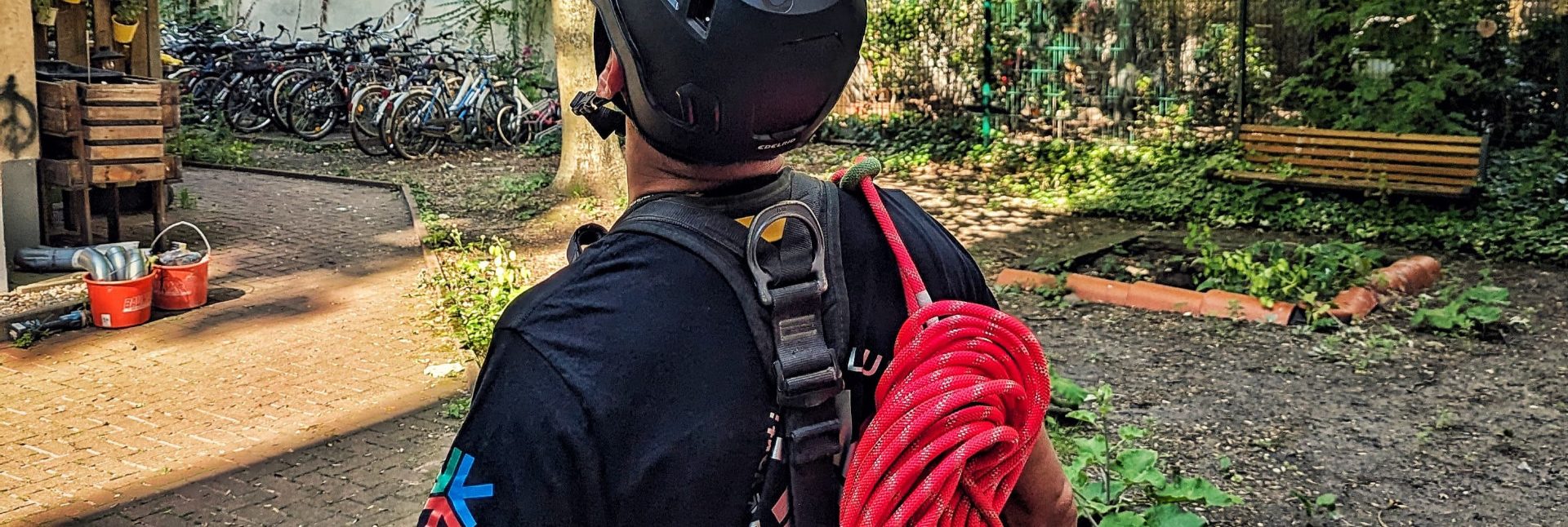 Industriekletterer mit Helm und Seil auf dem Weg zur Montage einer Absturzsicherung
